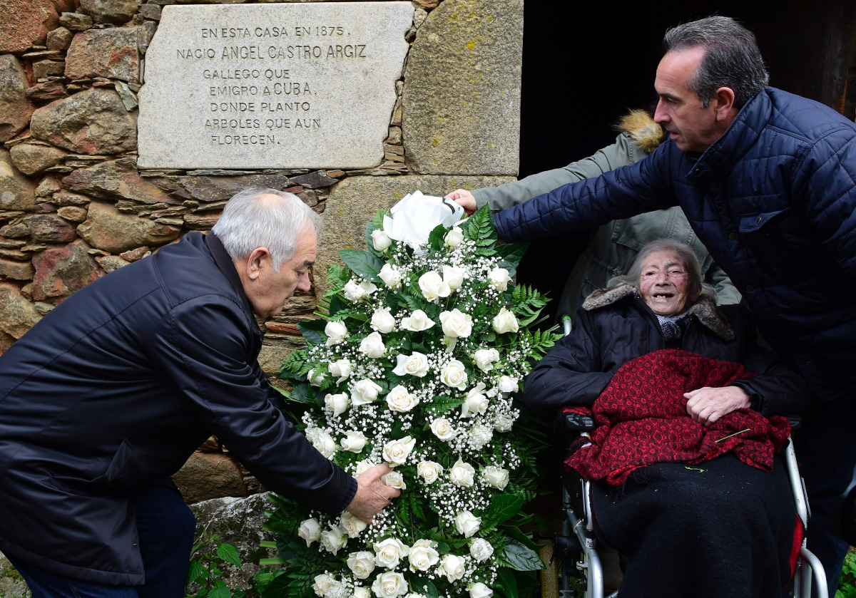 Lancara's Mayor, Dario Pineiro (R), late Cuban ex-President Fidel Castro's cousin Manuela Argiz (C), 103, and former Lancara Mayor, Eladio Capon, lay flowers outside the abandoned small limestone house of Castro's father, on which a plaque reads, 