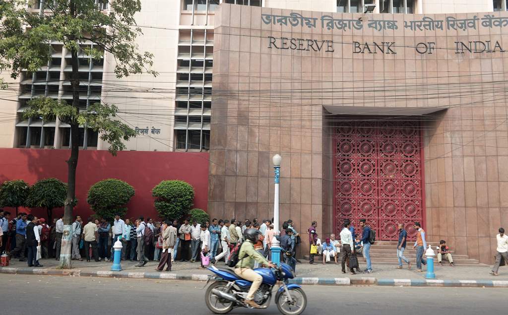 People stand in a queue outside the Reserve Bank of India during a nationwide strike called by major trade unions to protest against demonetisation in Kolkata on November 28, 2016. AFP / Dibyangshu SARKAR