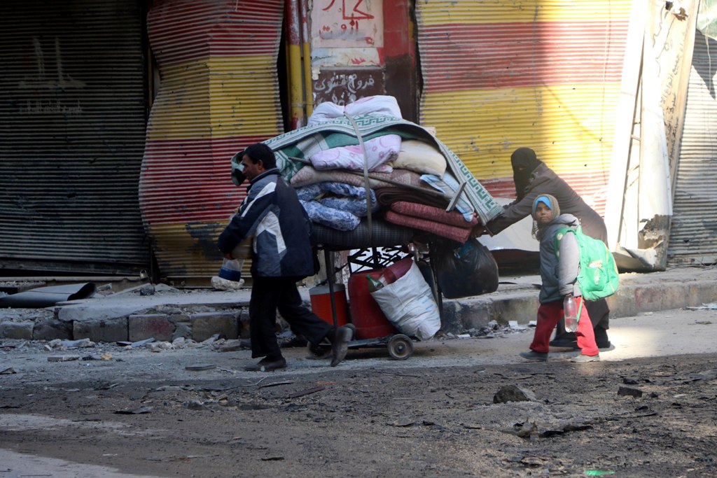 Residents escape from the scene of the air strikes carried out by the war crafts belonging to Russia and Assad regime forces in al-Shear neighbourhood of Aleppo, Syria on November 28, 2016. ( Mamun Ebu Ömer - Anadolu Agency )
