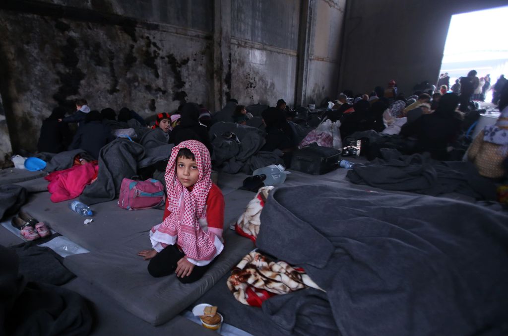 TOPSHOT - A Syrian boy, who fled with his family from rebel-held areas in the city of Aleppo, sits on November 30, 2016, inside a shelter in the neighberhood of Jibrin, east of Aleppo. / AFP.