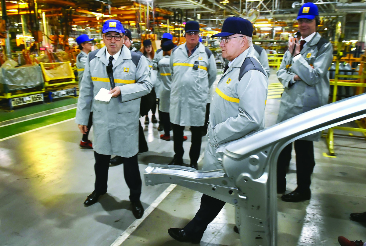 French Finance Minister Michel Sapin visits the assembly department of a plant of French multinational automobile manufacturer Renault in Moscow, yesterday.