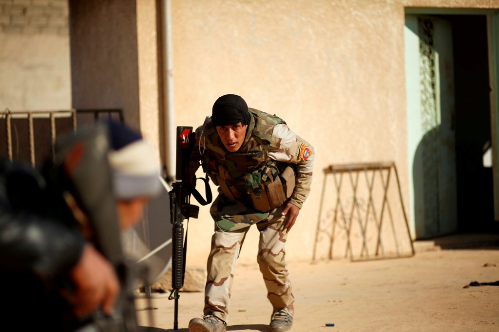 Iraqi soldiers take cover during clashes with Islamic State militants in the frontline in the neighbourhood of Intisar, eastern Mosul, Iraq, December 6, 2016. REUTERS/Ahmed Jadallah
