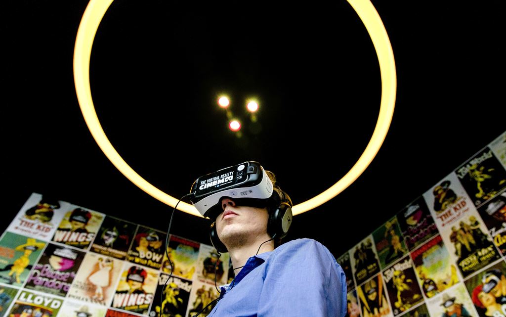 (FILES) This file photo taken on March 02, 2016 shows a man wearing headphones and VR glasses to watch films at the Virtual Reality cinema in Amsterdam, on March 2, 2016. AFP / ANP / Sander Koning