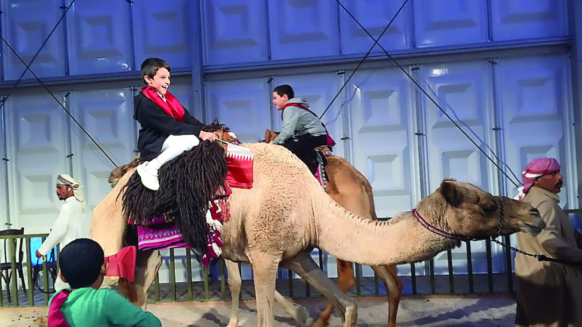 A child enjoys a camel ride at the ladies tent set up at Darb El Saai. 