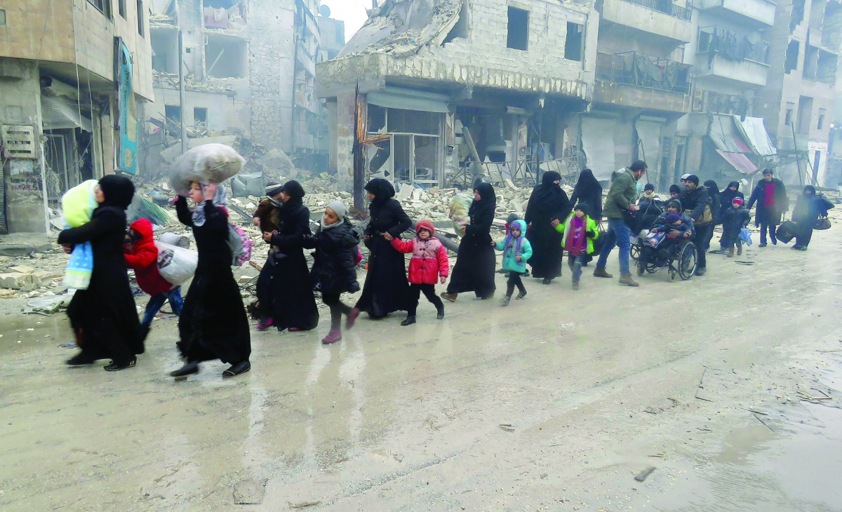 Syrian residents, fleeing violence in the restive Bustan Al Qasr neighbourhood, arrive in Aleppo's Fardos, after regime troops retook the area from rebel fighters, yesterday.
