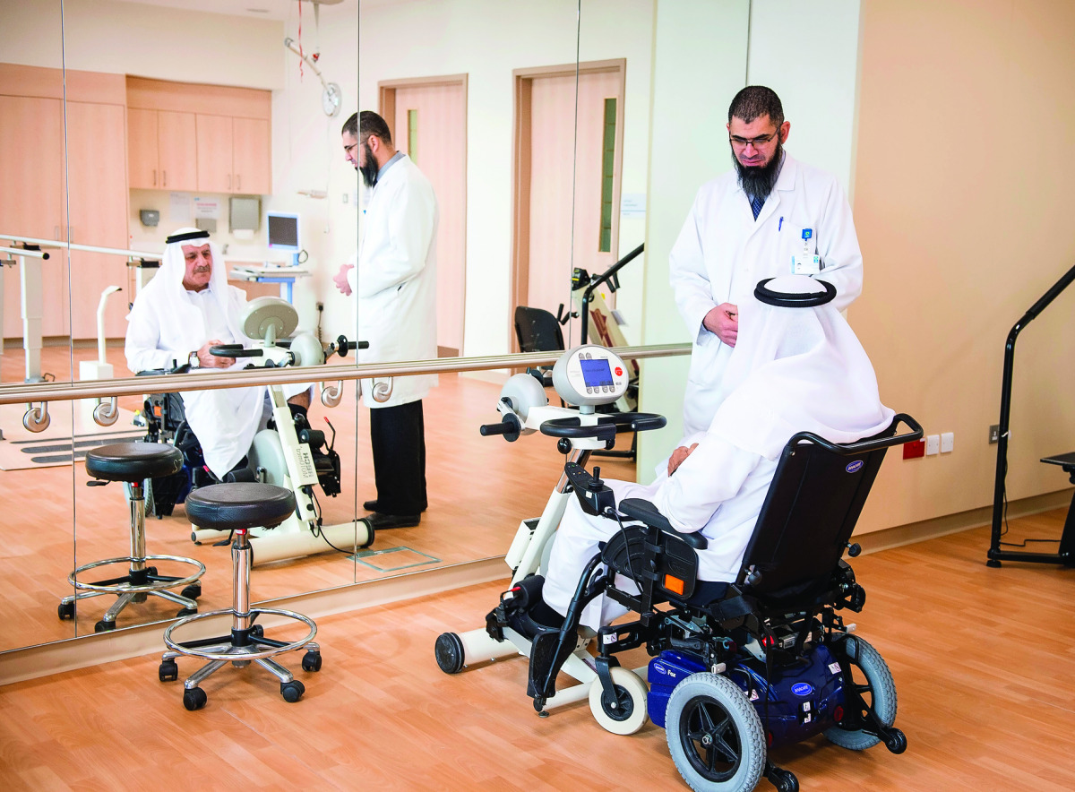 Physical therapist Basem Owais conducts a session in the QRI gymnasium with patient Jassim Mohammed Ali Abdulla.