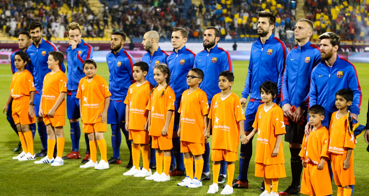Barcelona team pose for a photograph with six-year-old Afghan boy Murtaza Ahmadi and other kids before their match against Al Ahli in Doha.