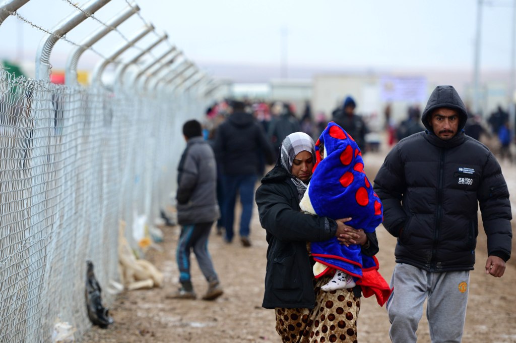 MOSUL, IRAQ - DECEMBER 14: Internally relocated Iraqi people walk near fence as they are facing lack of clean water, heating and electricity problems at the Khazir refugee camp in the Hasan Sam village near Mosul, Iraq on December 14, 2016. ( Hamit Hüseyi