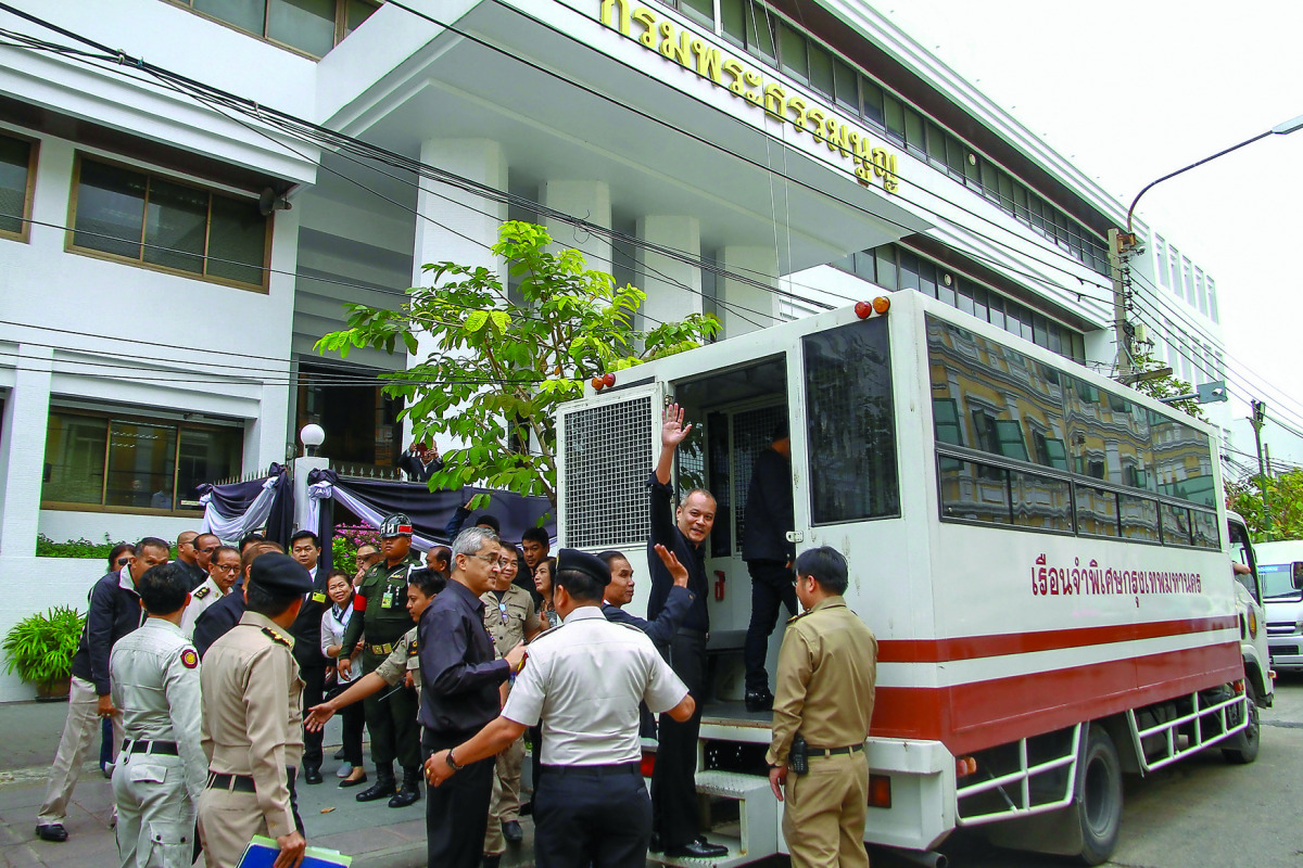 Red shirt leader Nattawut Saikua (centre) and other leaders wave to media as they leave at the Military court in Bangkok, yesterday.