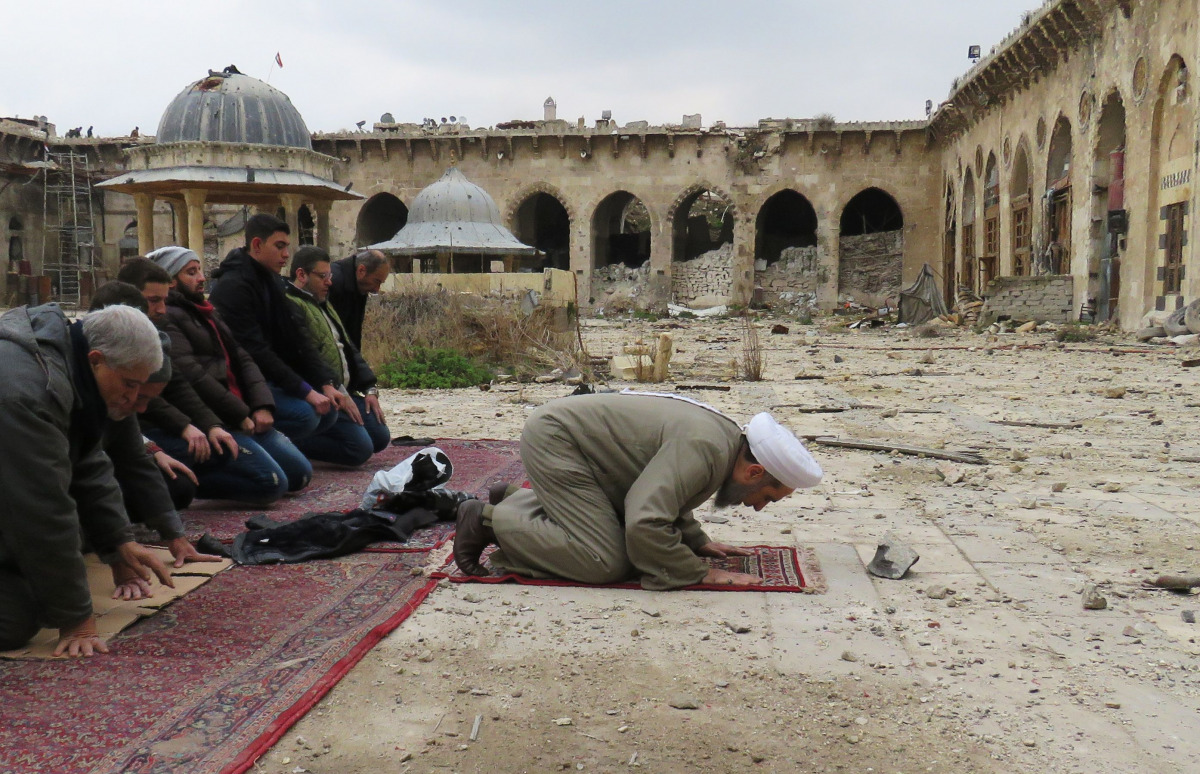 Syrians pray in the ancient Umayyad mosque in the old city of Aleppo on December 17, 2016, as civilians are allowed access to some neighbourhoods recently retaken by Syrian government forces. AFP