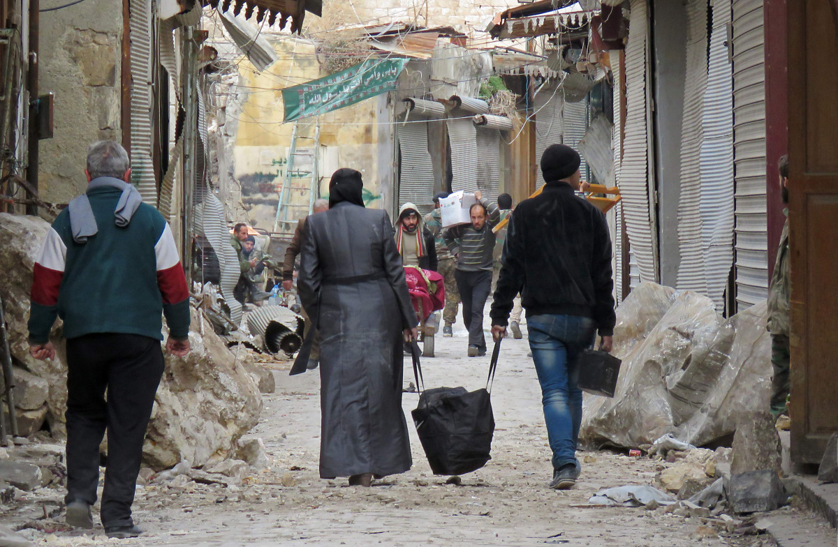 Syrians walk in the old market in the government-held old city of the northern embattled city of Aleppo on December 17, 2016. Trapped Syrian civilians and rebels waited desperately Saturday for evacuations to resume from an opposition-held enclave in Alep
