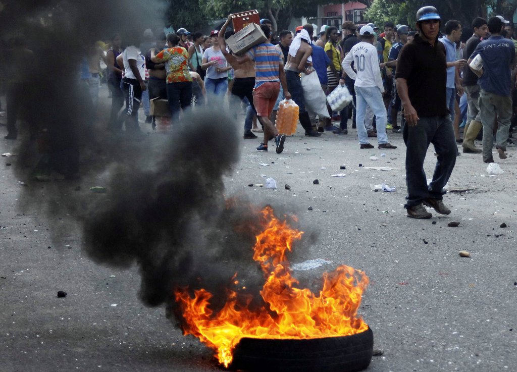 People carry goods taken from a food wholesaler after it was broken into, in La Fria, Venezuela December 17, 2016. REUTERS/Carlos Eduardo Ramirez
