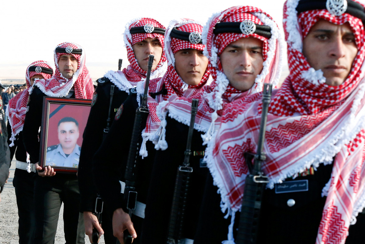 Guard of honor carry a picture of Lieutenant Colonel Saed Mayateh, who was killed during an attack yesterday, during his funeral in the city of Karak, Jordan, December 19, 2016. REUTERS/Muhammad Hamed