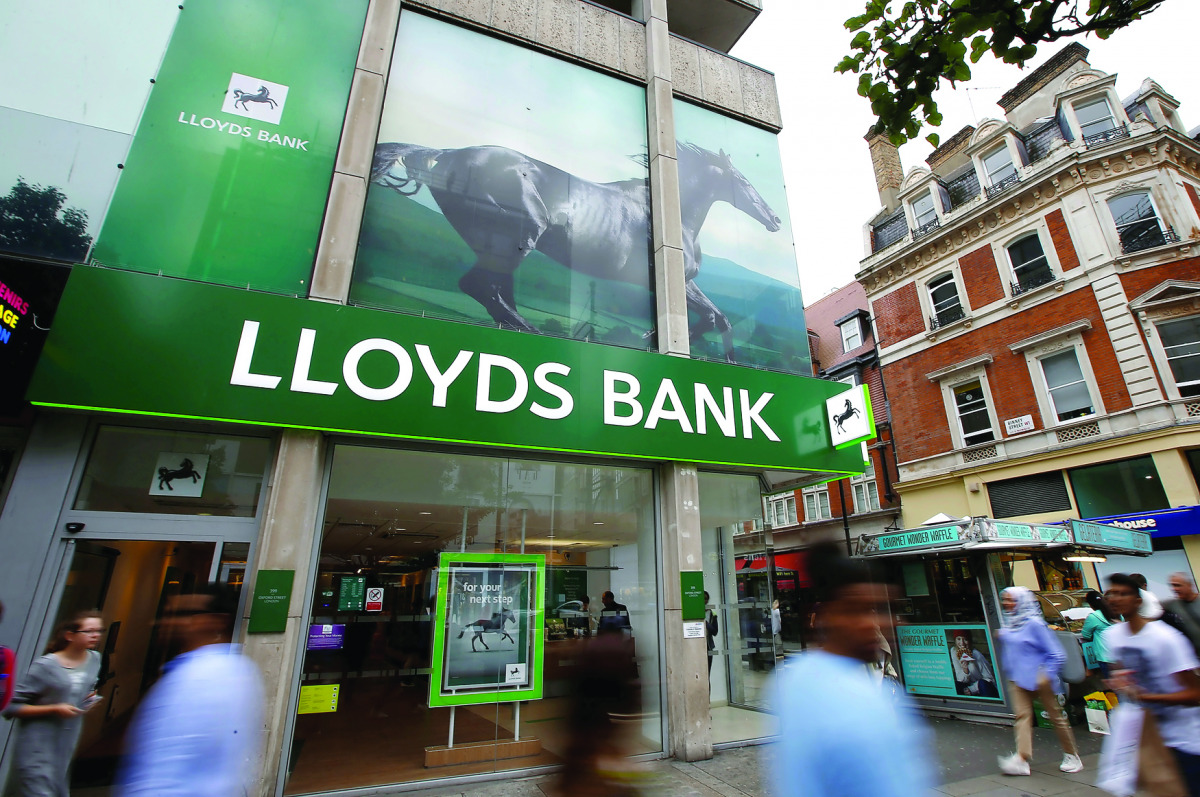 People walk past a branch of Lloyds Bank on Oxford Street in London.