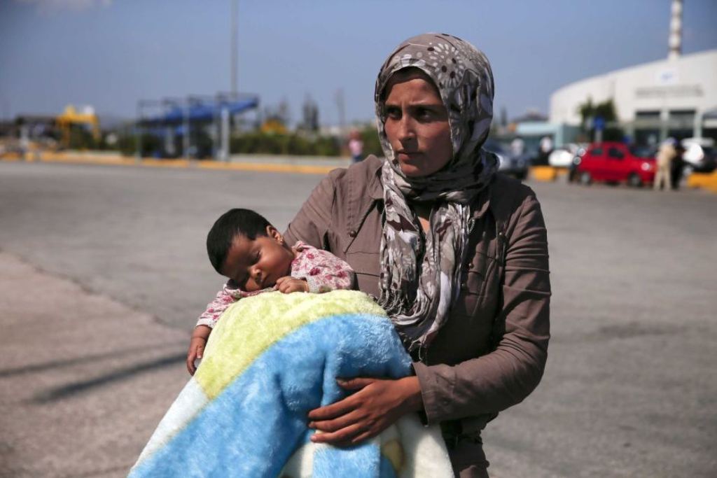 A Syrian asylum seeker holds her baby following their arrival onboard the Eleftherios Venizelos passenger ship at the port of Piraeus, near Athens, Greece September 8, 2015. / Reuters: Alkis Konstantinidis