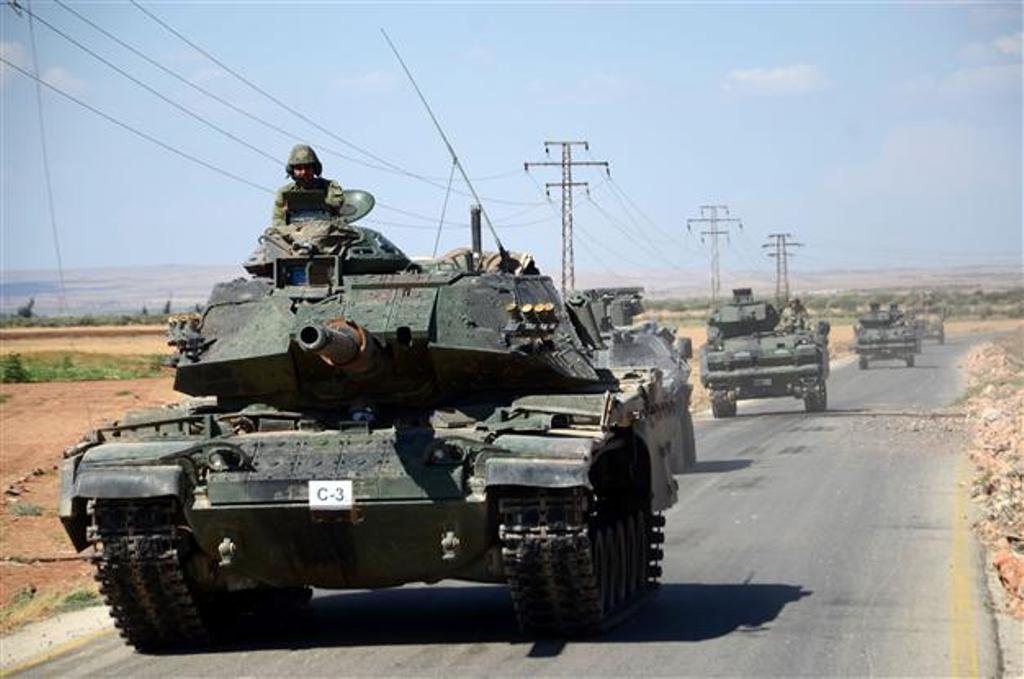 Turkish troops drive their tanks on a road near the Syrian village of al-Waqf and some 3km south of al-Rai. AFP photo.