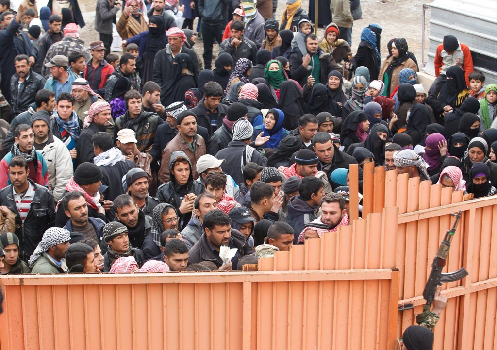 Displaced Iraqis from Mosul, who are fleeing from Islamic State militants, gather to receive aid in the east of Mosul, Iraq, December 21, 2016. REUTERS/Khalid al Mousily
