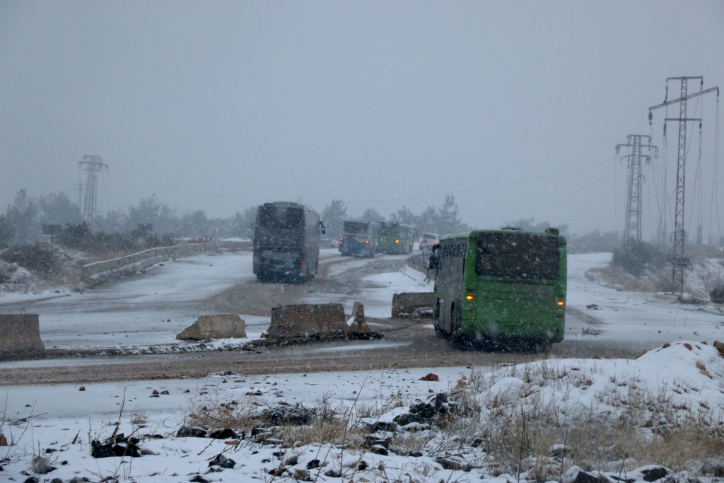 ALEPPO, SYRIA - DECEMBER 21: A convoy, evacuating civilians who flee from Assad regime supporter foreign terrorists controlled Fua and Kefraya towns those had been under siege by opposition groups, move forward Assad regime controlled western rural parts 