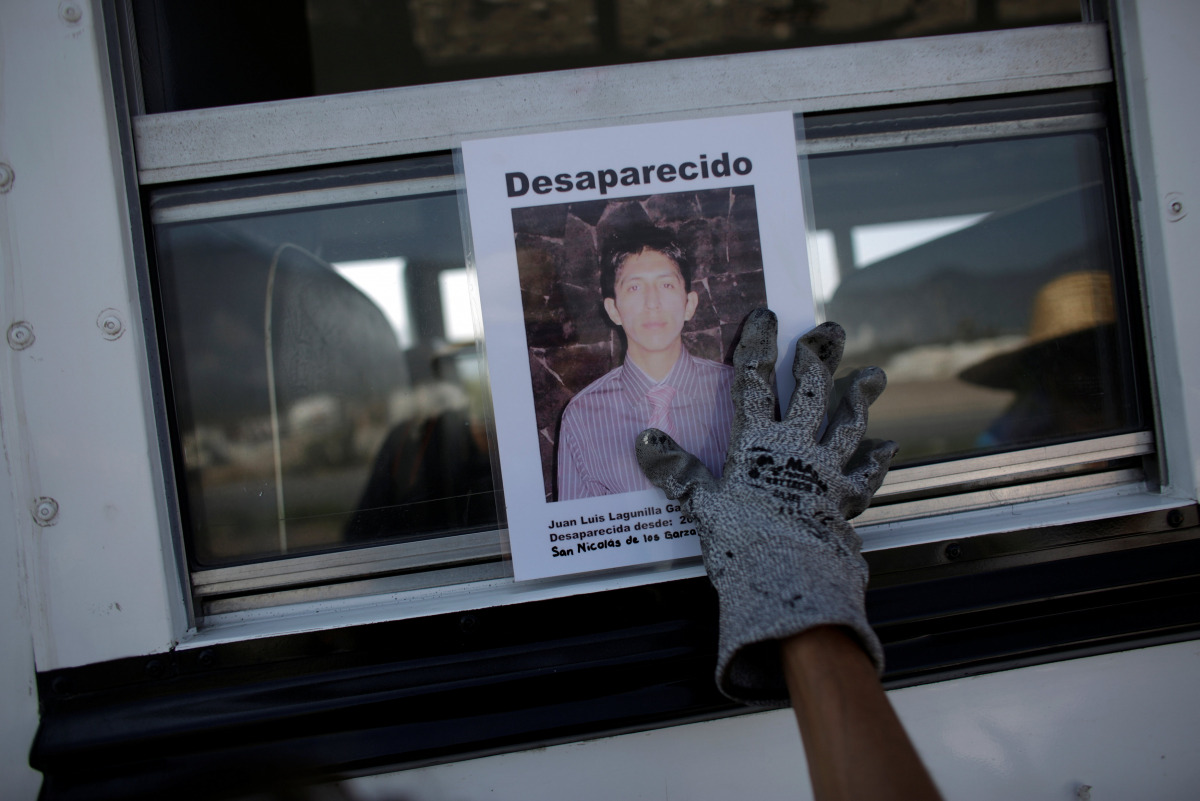 A woman holds the photograph of a relative lost in fight between drug gangs during a serach at Escobedo on the outskirts of Monterrey, Mexico, August 12, 2016 (REUTERS) 