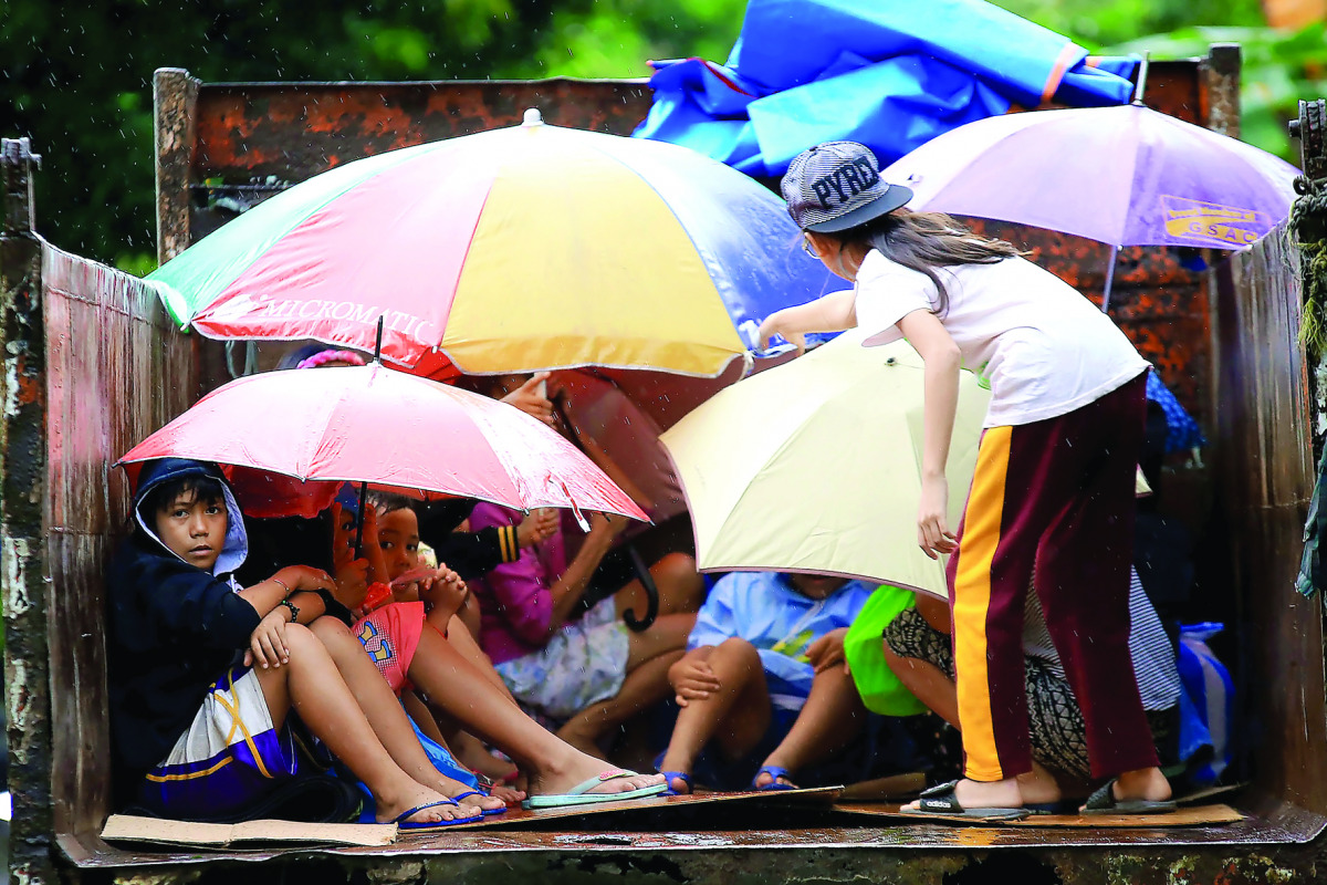 Young residents sit in a truck after the local government implemented preemptive evacuations at Barangay Matnog, Daraga, Albay province on December 25, 2016, due to the approaching typhoon Nock-Ten. Babies, toddlers and old people were loaded onto militar