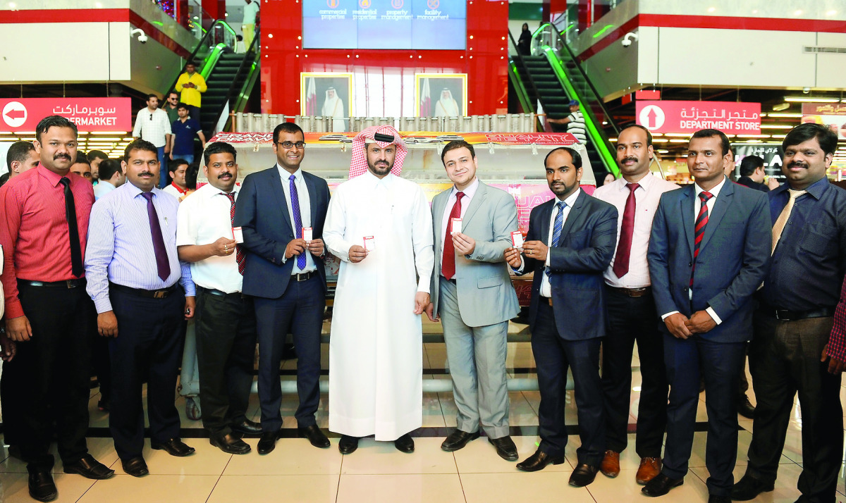 Ajayan Al Marri, an official from the Ministry of Economy and Commerce, with senior officials of Quality Hypermarket Group, after a raffle draw of the Shop and Drive sales promotion, at the Quality Mall, Al Hilal, in Doha yesterday. The winners of the dra