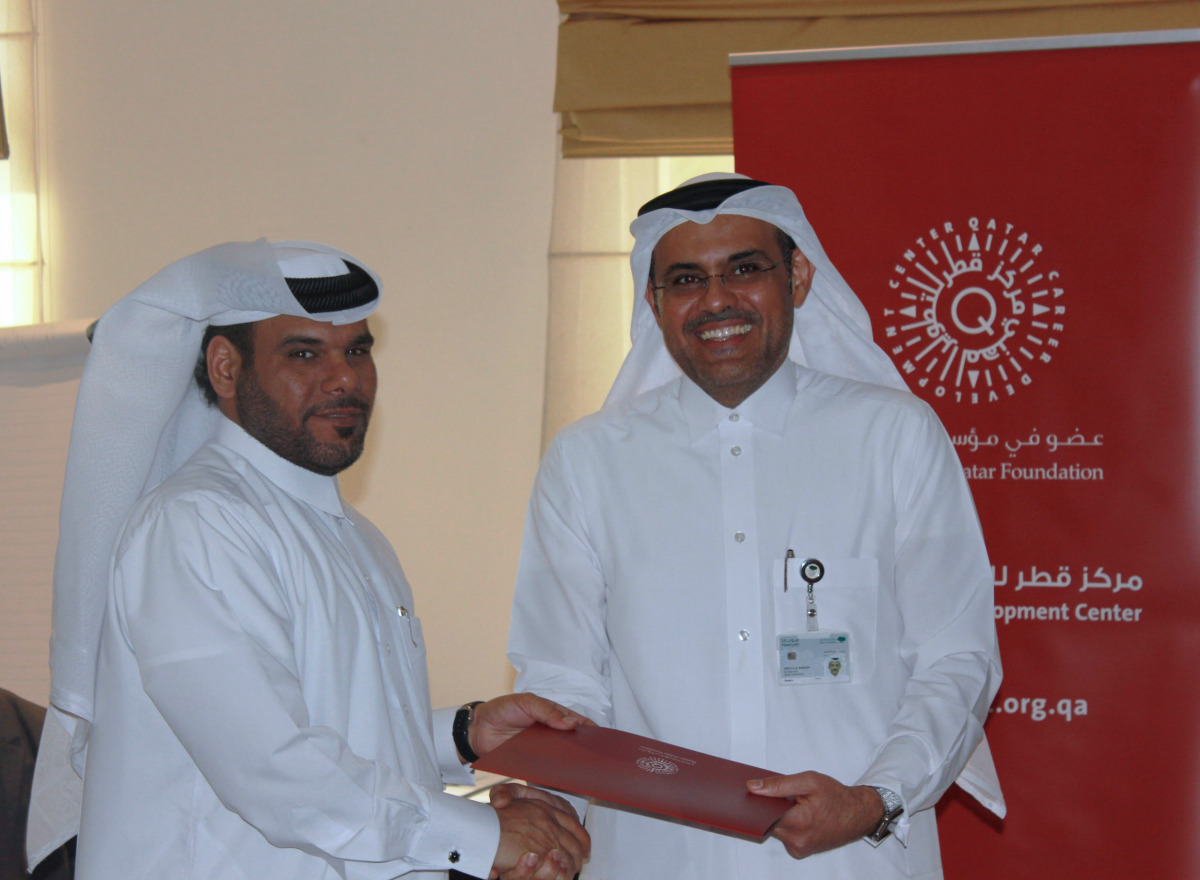 Abdulla Al Mansoori, Director of QCDC, hands out a completion certificate to one of the participants. 
