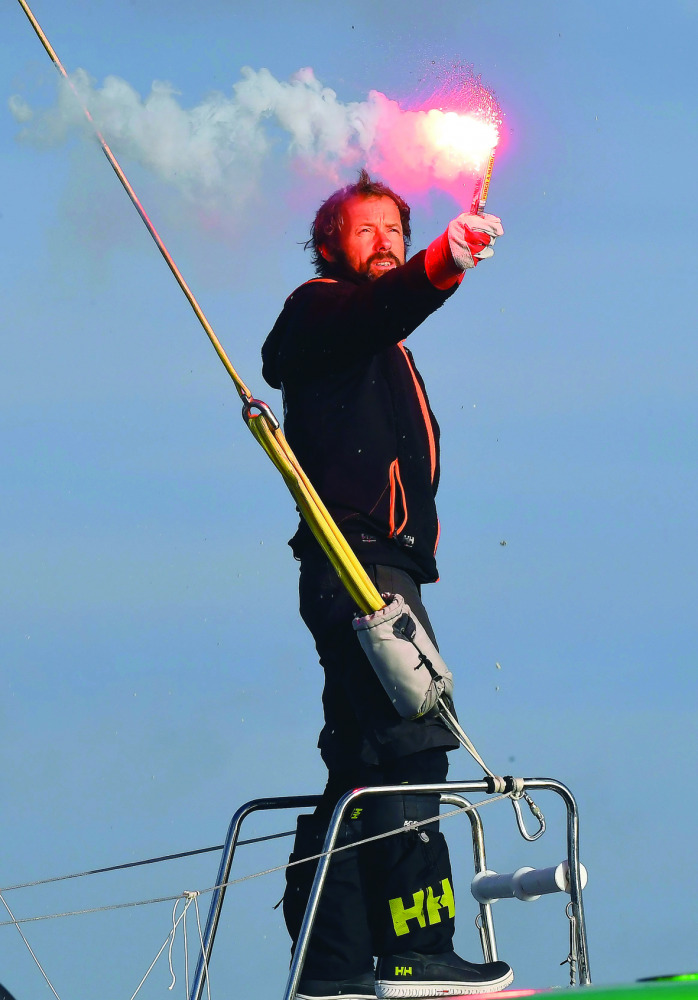 French skipper Thomas Coville holds a burning flare onboard his 