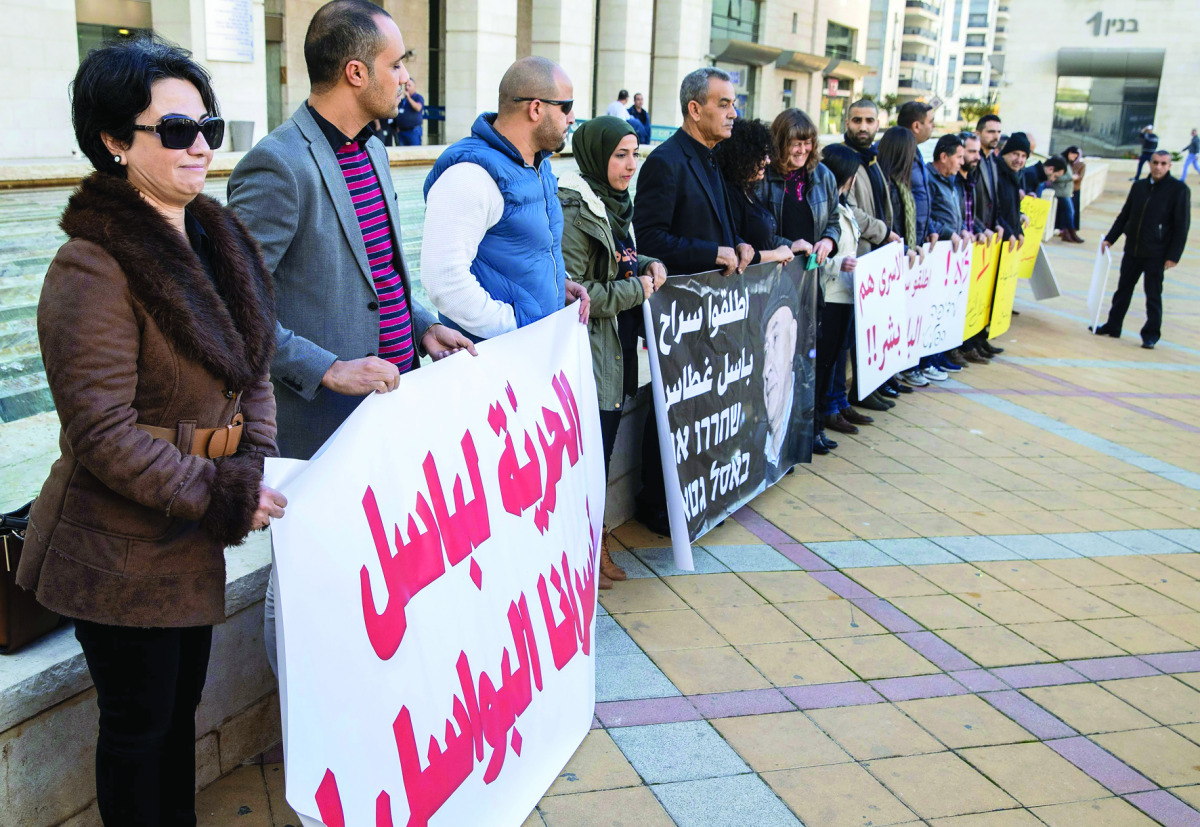 People demonstrate outside the Magistrate Court as Arab Israeli lawmaker Basel Ghattas undergoes a hearing, in Rishon Letzion, in central Israel, yesterday. Israeli police said they arrested an Arab lawmaker whose immunity has been lifted after he was sus