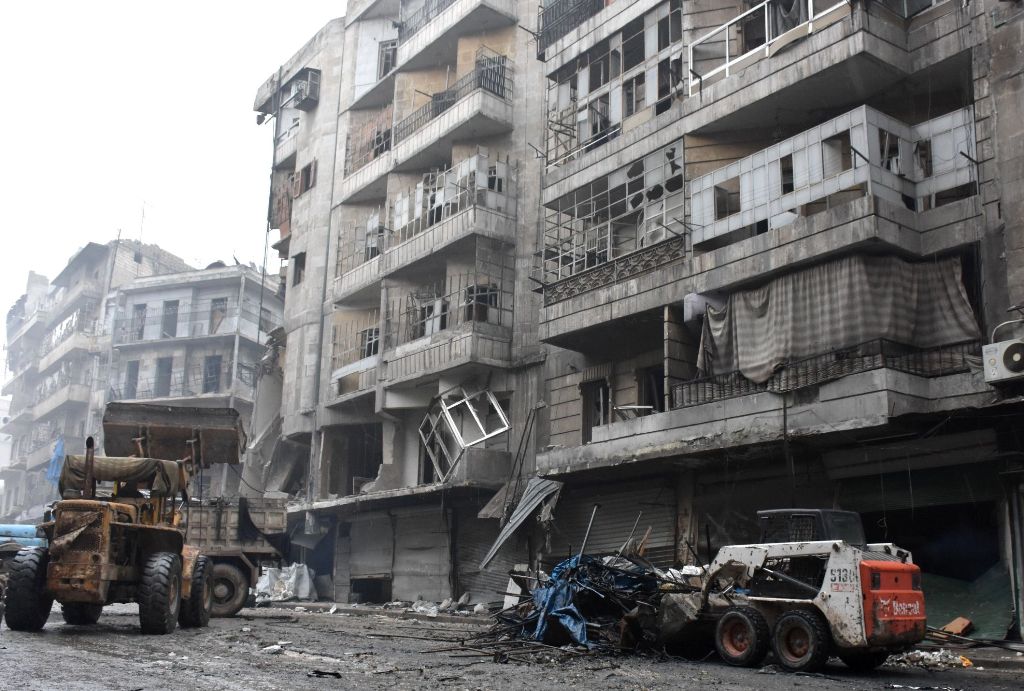 A tractor removes rubble as the Syrian government starts to clean up areas formerly held by opposition forces in the northern city of Aleppo on December 27, 2016, in the Shaar district.  AFP / George OURFALIAN