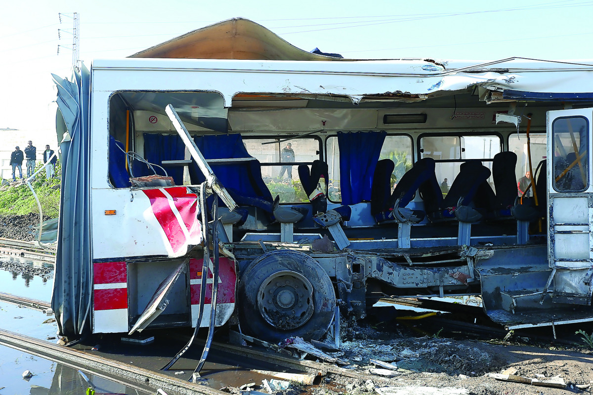 Tunisian security officers and civil defence team members gather at the site of a train and bus collision near Tunis yesterday. 
