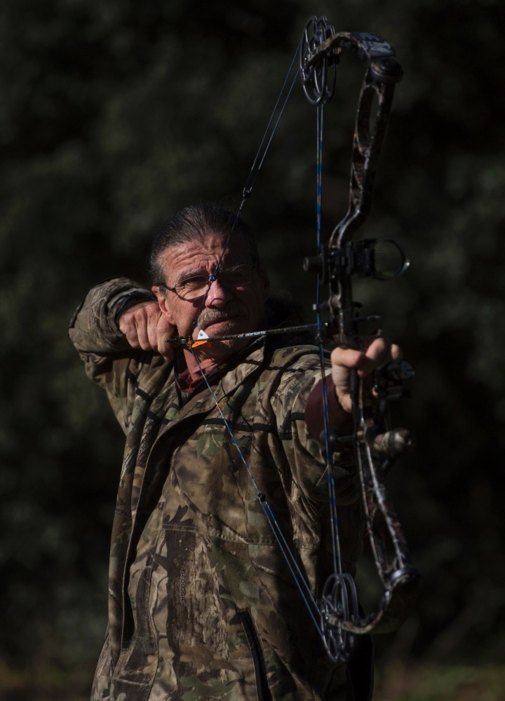 Hunter, Javier Sintes training with his bow on the outskirts of San Agustin de Guadalix near Madrid on December 12, 2016. It's a scene straight out of Medieval times set in modern-day Madrid: an archer dressed in camouflage gear, stationed in a tree at ni