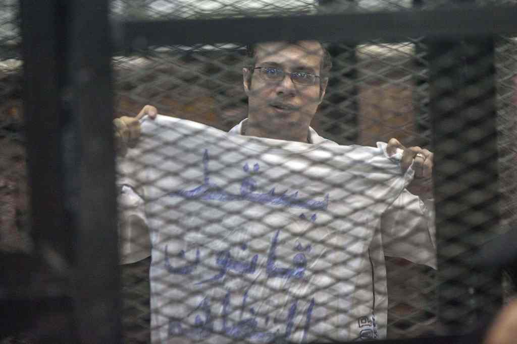 (FILES) This file photo taken in Cairo on December 08, 2013 shows political activist and coordinator of the April 6 Movement, Ahmed Maher, during his trial over an unlicensed and violent demonstration. AFP / MAHMOUD KHALED
