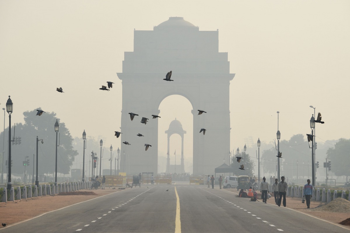 Indian pedestrians walk near the India Gate monument amid heavy smog in New Delhi, October 28, 2016 (AFP)