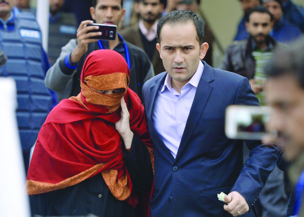 The wife of a Pakistani judge, accused of torturing her 10-year-old maid,  is escorted by her brother as they leave the Supreme Court in Islamabad, yesterday. 
