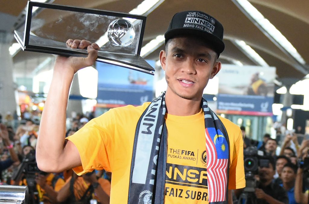Malaysian football player Mohd Faiz Subri, an attacking midfielder for Penang FA in the Malaysian Super League, holds his 2016 FIFA Puskas Award plaque following his arrival from Zurich at the Kuala Lumpur International Airport in Sepang on January 11, 20
