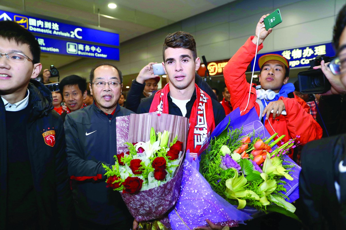 Brazilian international Oscar (centre) is escorted as he arrives at Shanghai airport in China in this January 3 file picture.
