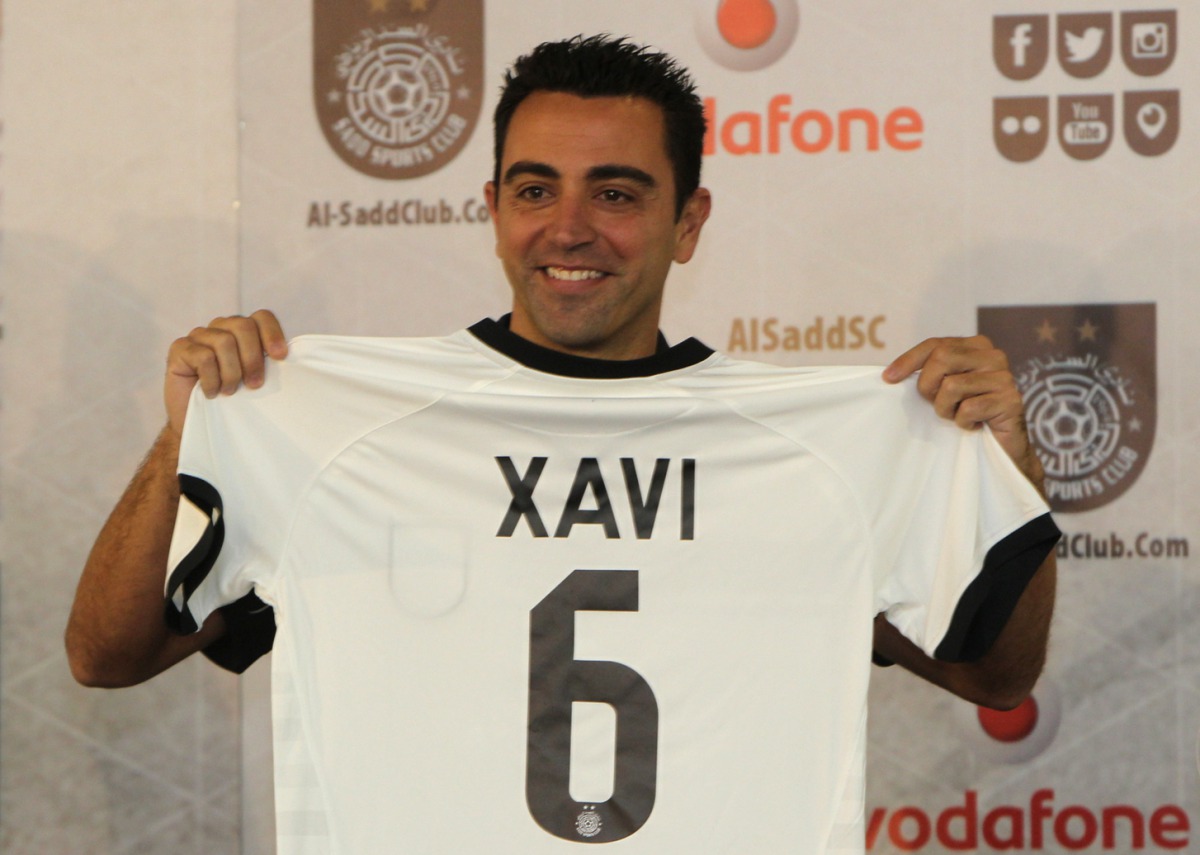 This file photo taken on June 11, 2015 shows Barcelona legend Xavi Hernandez posing for a photo with his new Al-Sadd shirt after signing a two-year contract with the Qatari team in Doha. Barcelona great Xavi Hernandez has agreed a year's extension to his 