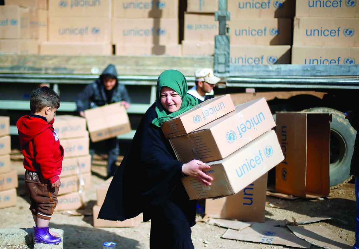 Displaced people who fled the clashes receive aid in northern Mosul, Iraq, yesterday.