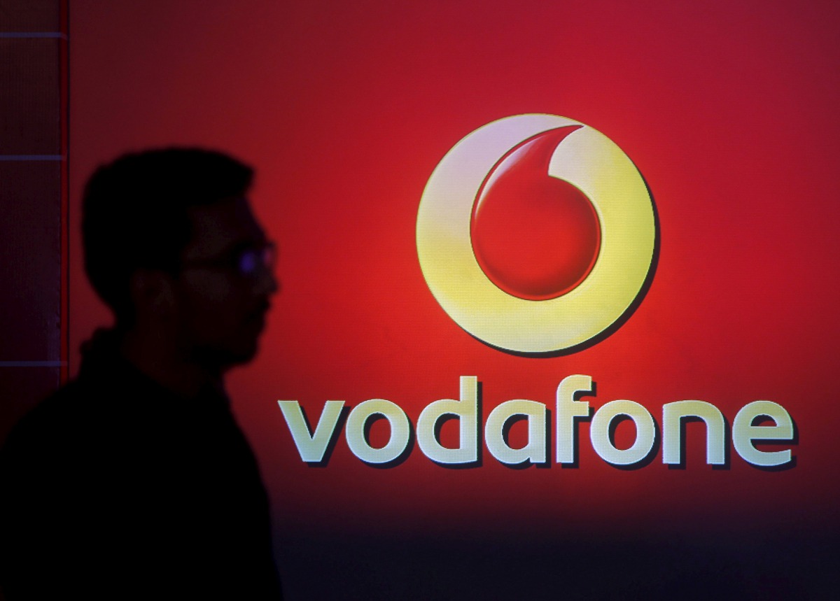 A man casts silhouette onto an electronic screen displaying logo of Vodafone India after a news conference to announce the half year results in Mumbai, India. (REUTERS/Shailesh Andrade/File Photo)