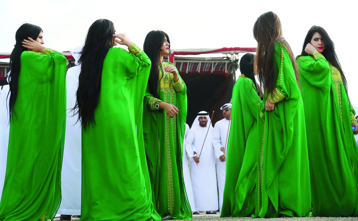 Emiratis perform a traditional dance during the camel festival at the Sweihan racecourse, in Al-Ain on the outskirts of Abu Dhabi yesterday. The festival includes a camel beauty contest, a traditional souq, a camel auction, and competitions for traditiona