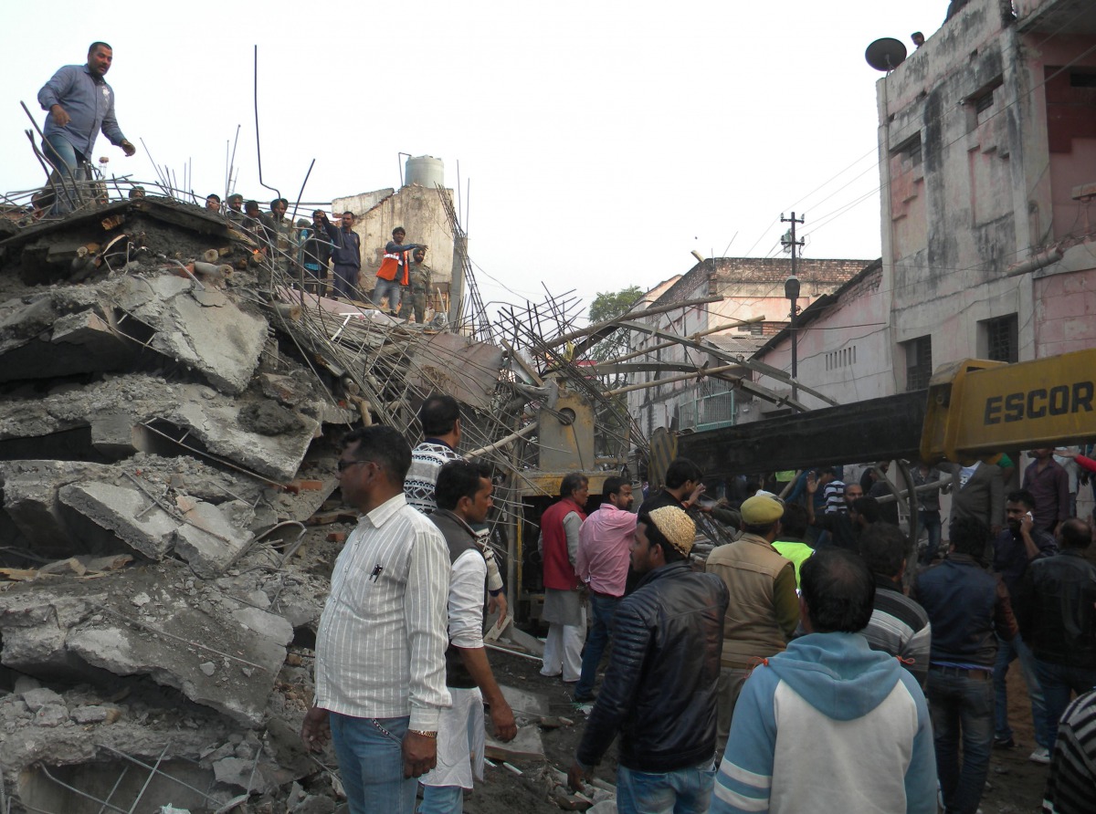 Indian residents stand near an under-construction building which collapsed in Kanpur on February 1, 2017. Indian police and army personnel are carrying out a resuce operation after an under-construction building collapsed in the state of Uttar Pradesh. Tw