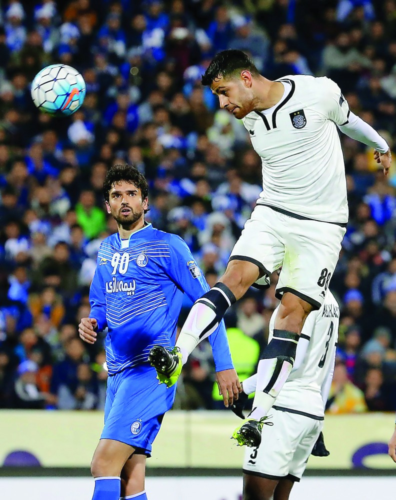 Qatar's Al Sadd player Morteza Pouraliganji (right) heads the ball in front of Leandro Padovani of Iran's Esteghlal during their AFC Champions League play-off match at the Azadi Stadium in Tehran, yesterday.