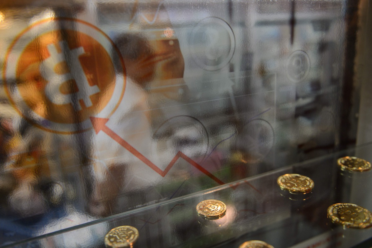 A man walking past a display cabinet containing models of Bitcoins in Hong Kong on August 3, 2016 (AFP / Anthony Wallace) 