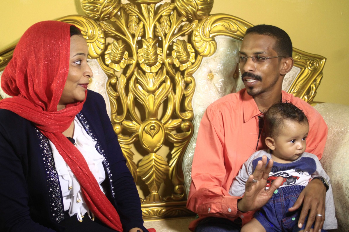 Sudanese family emigrating to the US, Mohamed al-Khatim (R), his wife Samah al-Amin (L) and their eight month old son are seen in Khartoum on February 10, 2017.  AFP / Ebrahim Hamid