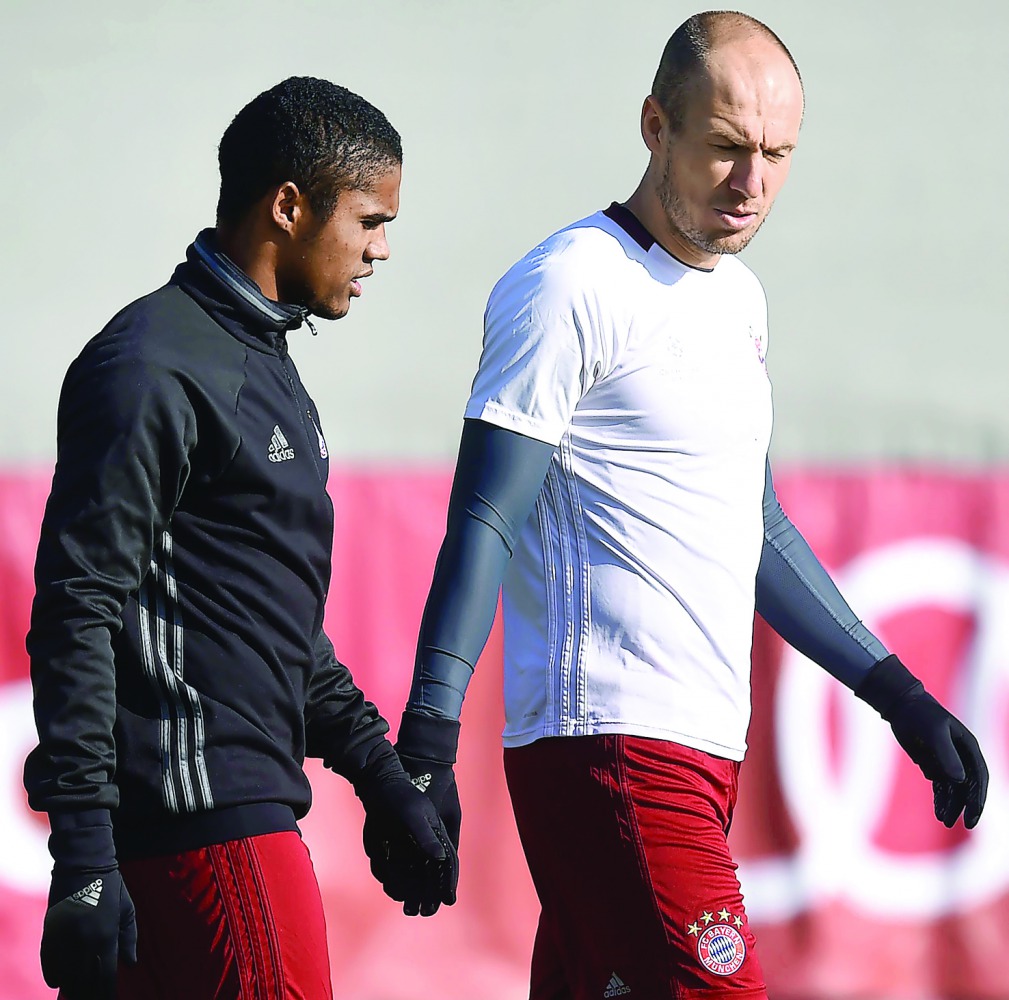 Bayern Munich's Brazilian midfielder Douglas Costa (L) and Bayern Munich's Dutch midfielder Arjen Robben (R) arrive for the final team training at the team training's area in Munich, southern Germany, on February 14, 2017, on the eve of the UEFA Champions