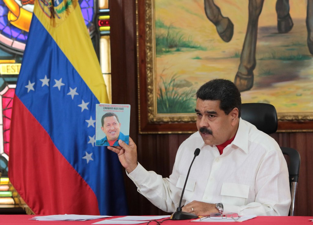 Venezuela's President Nicolas Maduro holds an image of Venezuela's late President Hugo Chavez as he speaks during a meeting with governors in Caracas, Venezuela February 14, 2017. Miraflores Palace/Handout 