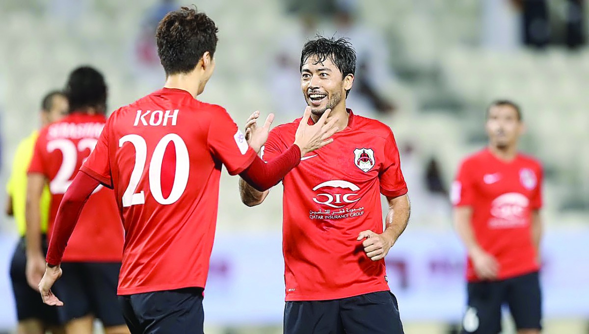 Al Rayyan's Rodrigo Tabata (right) celebrates with team-mate Myongin Koh after scoring one of his goals during their QSL match against Muaither SC yesterday. 
