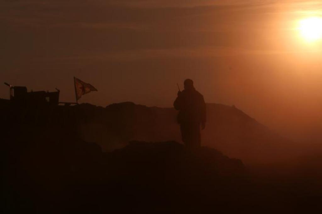 A Syrian Democratic Forces (SDF) fighter stands near a flag in northern Raqqa province, Syria February 6, 2017. REUTERS/Rodi Said