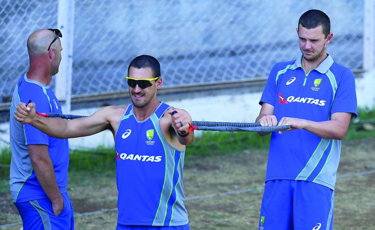Australia's Mitchell Starc (left) and his team-mate Josh Hazlewood stretch during the final day of three-day practice match against India A at the Brabourne Stadium in Mumbai on Sunday. 