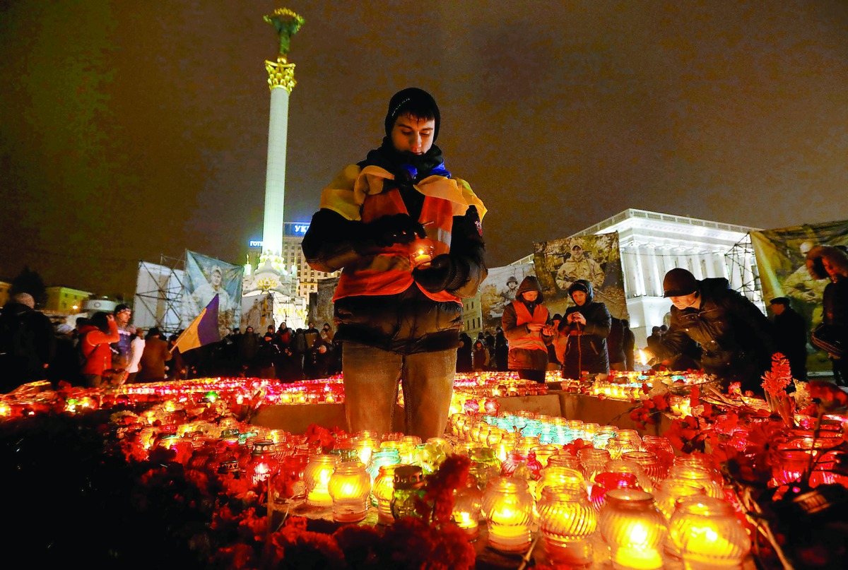 Remembering a revolution: A man holds a candle as he commemorates the third anniversary of Ukrainian mass protests in 2014 that sparked a revolution, in central Kiev, yesterday.